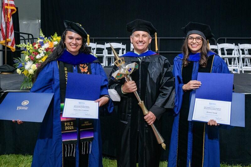 three people wearing academic regalia