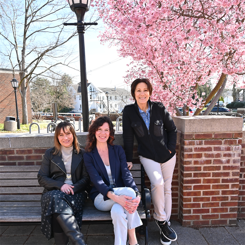 three women at a bench outside